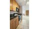 Kitchen featuring wood cabinets, black granite countertops, tile flooring, and stainless appliances at 850 20Th St # 201, Boulder, CO 80302