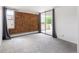 Living room with balcony access, brick accent wall and neutral carpet at 850 20Th St # 201, Boulder, CO 80302