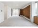 Spacious living room featuring sliding glass doors to the balcony, a brick wall, and neutral carpet at 850 20Th St # 201, Boulder, CO 80302