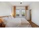 Sunlit bedroom with hardwood floors, white walls and a large window view at 3725 S Acoma St, Englewood, CO 80110