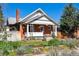 Attractive brick home with a well-maintained yard and front porch, enhanced by colorful flowerbeds at 3725 S Acoma St, Englewood, CO 80110