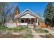 Charming brick bungalow featuring a landscaped front yard and inviting front porch on a sunny day at 3725 S Acoma St, Englewood, CO 80110
