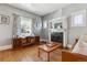 Cozy living room with hardwood floors, a vintage fireplace, and a large window at 3725 S Acoma St, Englewood, CO 80110