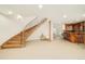 Finished basement featuring a wood staircase, bar area, and open layout at 4845 S Gaylord St, Cherry Hills Village, CO 80113