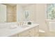 Bright bathroom vanity with marble countertops, gold hardware, and shower at 4845 S Gaylord St, Cherry Hills Village, CO 80113