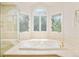 Bright bathroom features tile flooring, large tub, and stained glass window at 4845 S Gaylord St, Cherry Hills Village, CO 80113