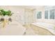 Bright bathroom boasts tile flooring, glass shower, tub, and large windows at 4845 S Gaylord St, Cherry Hills Village, CO 80113