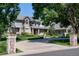 Charming two-story home with brick and siding exterior, featuring a circular driveway and manicured landscaping at 4845 S Gaylord St, Cherry Hills Village, CO 80113