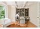 Office featuring wood floors, custom built-ins, and a glass desk with comfortable seating at 4845 S Gaylord St, Cherry Hills Village, CO 80113