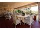 Inviting covered porch with white brick, comfortable seating, and a dining table at 4845 S Gaylord St, Cherry Hills Village, CO 80113