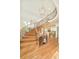 Elegant curved staircase with wrought iron spindles and light wood treads, overlooking the open-concept kitchen at 4845 S Gaylord St, Cherry Hills Village, CO 80113
