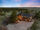 Stunning aerial view of a home on a large lot with a circular driveway and mountain views at 7465 Kelty Trl, Franktown, CO 80116