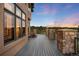 Spacious back deck with stone pillars, wood flooring, and scenic views of the surrounding landscape at 7465 Kelty Trl, Franktown, CO 80116