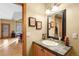 Neutral bathroom featuring a decorative mirror and tiled countertop with access to the living room at 7465 Kelty Trl, Franktown, CO 80116