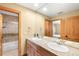 Bathroom with double sinks, wood cabinets and a view into the walk-in shower and bedroom at 7465 Kelty Trl, Franktown, CO 80116