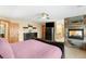 Bedroom showcasing a fireplace, a TV, and an adjoining bathroom and vanity area at 7465 Kelty Trl, Franktown, CO 80116