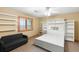 Bright bedroom with built-in shelves, a sofa, and a window showcasing the outdoor view at 7465 Kelty Trl, Franktown, CO 80116