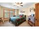 Cozy bedroom with a lodge style bed, ceiling fan, and window with plantation shutters at 7465 Kelty Trl, Franktown, CO 80116