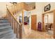Grand foyer with wood floors, a staircase with carpet runner and doors leading to other rooms at 7465 Kelty Trl, Franktown, CO 80116