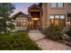 Charming front entrance featuring a covered porch, stone detailing, and a well-manicured landscape at 7465 Kelty Trl, Franktown, CO 80116