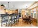 Open concept kitchen with bar seating, wood cabinets and stainless steel appliances, adjacent to dining area at 7465 Kelty Trl, Franktown, CO 80116