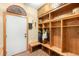 Mudroom featuring custom wood built-ins, bench seating, and brick flooring at 7465 Kelty Trl, Franktown, CO 80116