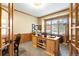 Well-lit home office featuring wood trim, a large window, and custom built-in shelving at 7465 Kelty Trl, Franktown, CO 80116