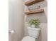 Neutral colored bathroom featuring a toilet with decorative shelves, wire basket, and a roll of toilet paper at 1933 Griffin Dr, Brighton, CO 80601