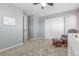 Cozy bedroom features plush carpeting, a ceiling fan, and a comfortable rocking chair and ottoman at 1933 Griffin Dr, Brighton, CO 80601
