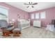 Pink Bedroom with glider, crib, changing table, and windows, creating a cozy atmosphere at 1933 Griffin Dr, Brighton, CO 80601