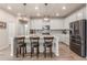 The kitchen features an island with bar stools, stainless steel appliances and modern pendant lighting fixtures at 1933 Griffin Dr, Brighton, CO 80601