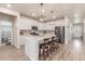 Bright kitchen with white cabinets, stainless steel appliances, large center island, and contemporary light fixtures at 1933 Griffin Dr, Brighton, CO 80601
