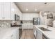 Modern kitchen with white cabinets, stainless steel appliances, island with bar seating, and stylish backsplash at 1933 Griffin Dr, Brighton, CO 80601