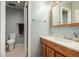 Bathroom features a white toilet, vanity with wood cabinets and a tile floor at 902 S Yukon St, Lakewood, CO 80226