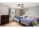 Cozy bedroom featuring twin beds, a ceiling fan, and a window at 902 S Yukon St, Lakewood, CO 80226