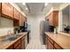 Efficient kitchen with stainless appliances, wood cabinets, and ample counter space at 902 S Yukon St, Lakewood, CO 80226