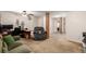 Comfortable living room features neutral carpet, sofa, chair, and wooden columns at 902 S Yukon St, Lakewood, CO 80226