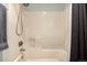 Shower includes shower head, handle, shelf, and light gray shower curtain and a towel at 902 S Yukon St, Lakewood, CO 80226