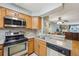 Functional kitchen featuring wood cabinetry, stainless steel appliances, and an eat-in bar at 912 S Paris Ct, Aurora, CO 80012