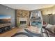Inviting living room featuring a stone fireplace, sliding glass doors to deck, and hardwood floors at 912 S Paris Ct, Aurora, CO 80012