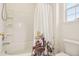 Bathroom features a tub with white tile surround and colorful floral shower curtain at 7371 S Mobile St, Aurora, CO 80016