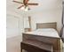 Bright bedroom with a wooden bed, ceiling fan, and a built-in vanity with mirror at 7371 S Mobile St, Aurora, CO 80016