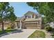 Charming two-story home featuring manicured lawn, mature trees, and a spacious two car garage at 7371 S Mobile St, Aurora, CO 80016