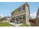 Exterior view of the house with a back patio, grassy lawn, and fenced yard at 7371 S Mobile St, Aurora, CO 80016