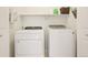 Bright laundry room featuring a white washer and dryer with storage shelf at 7371 S Mobile St, Aurora, CO 80016