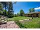 Expansive backyard featuring a well-maintained lawn, patio area, and mature trees at 2744 S Newton Way, Denver, CO 80236