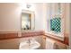 Charming bathroom featuring a pedestal sink, vintage tile, and decorative window at 2744 S Newton Way, Denver, CO 80236