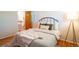 Cozy bedroom showcasing a bed with stylish linens, hardwood floors, and a standing lamp at 2744 S Newton Way, Denver, CO 80236