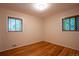 Simple bedroom featuring hardwood floors and two bright windows with tree views at 2744 S Newton Way, Denver, CO 80236