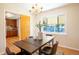 Inviting dining room with a view of the backyard and kitchen, featuring a dark wood table and chandelier at 2744 S Newton Way, Denver, CO 80236